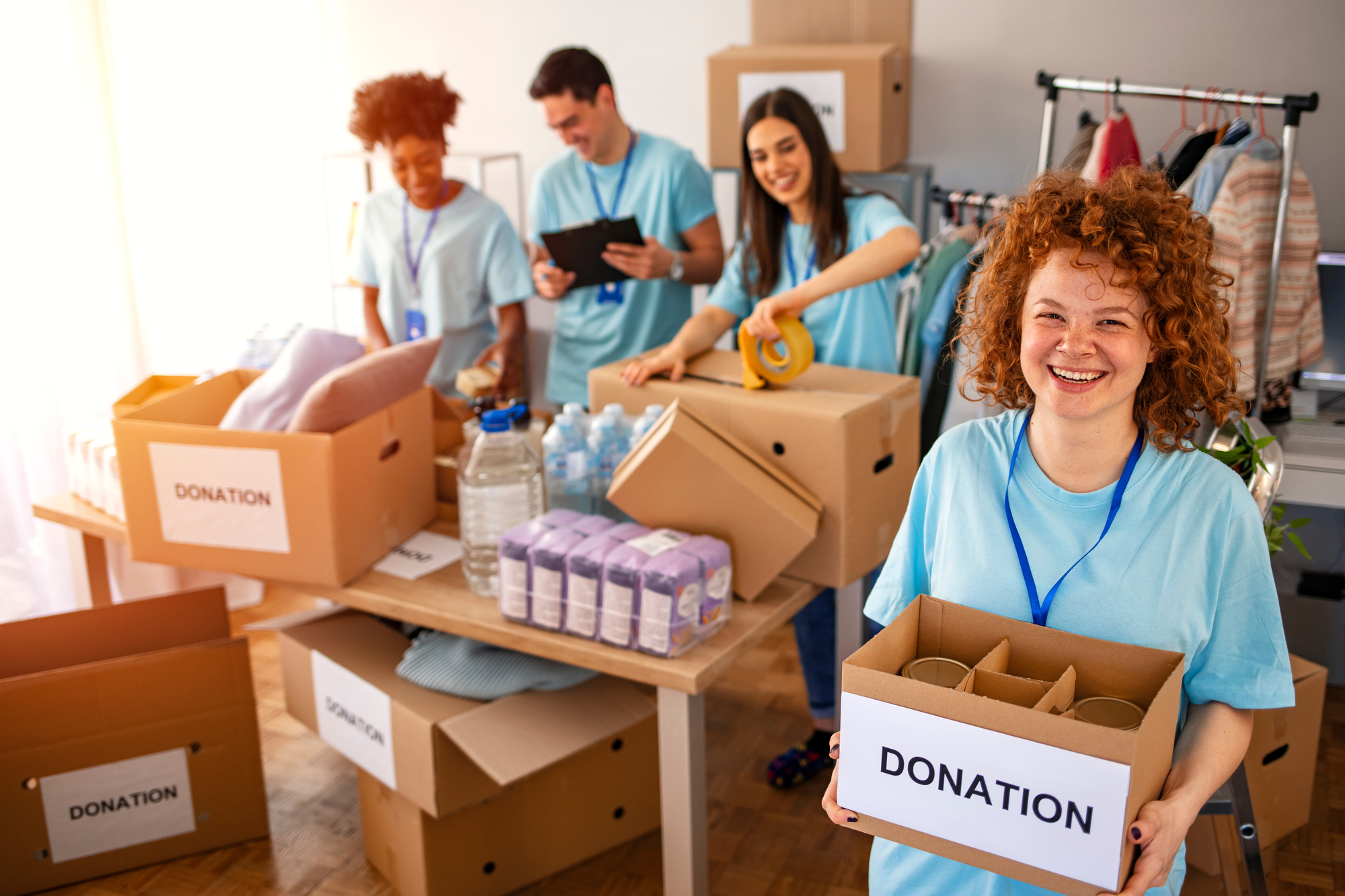 A group of people holds donation boxes with signs